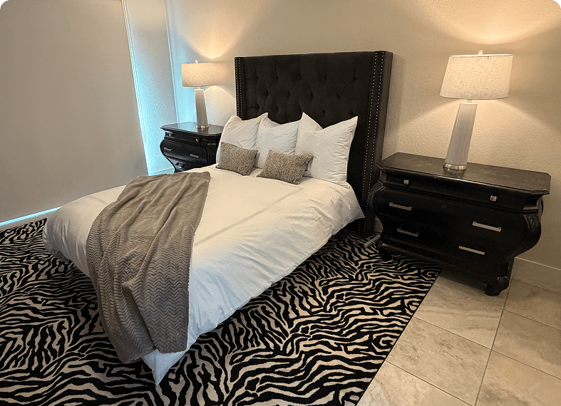 Cozy bedroom with a tufted headboard and zebra-print rug.