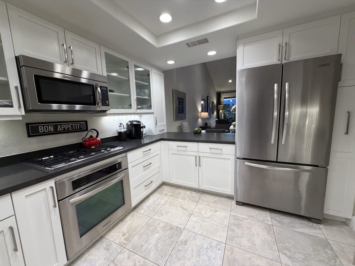 Modern kitchen with stainless steel appliances and white cabinetry.