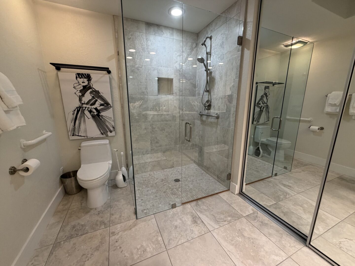 Modern bathroom with glass shower and stylish artwork.