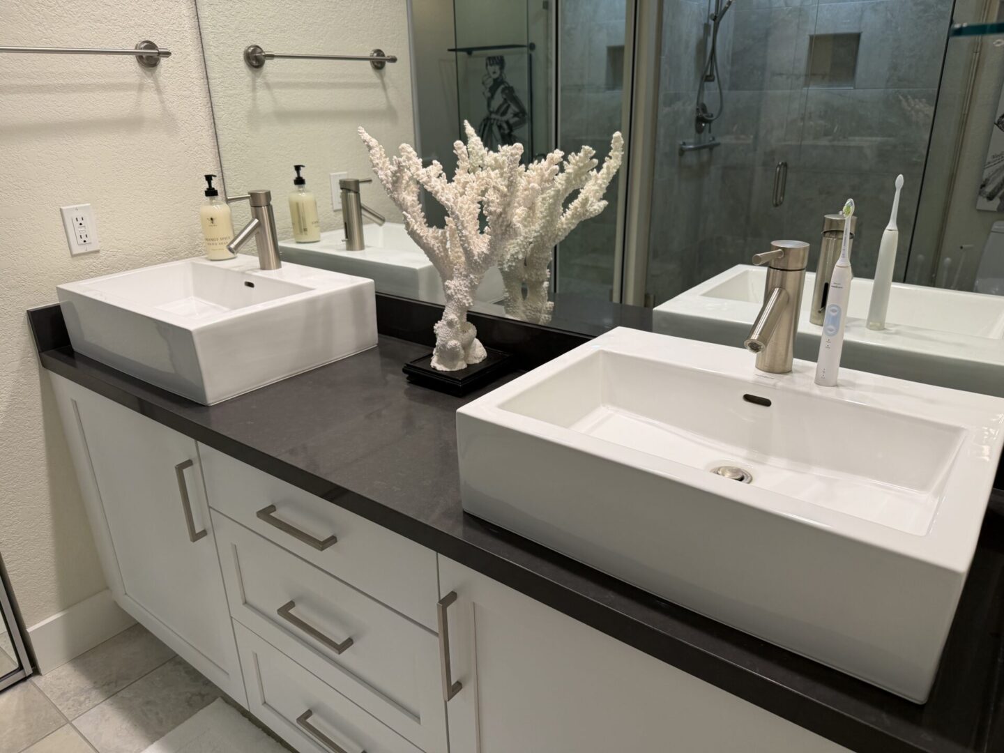 Modern double sink bathroom vanity with coral decor.